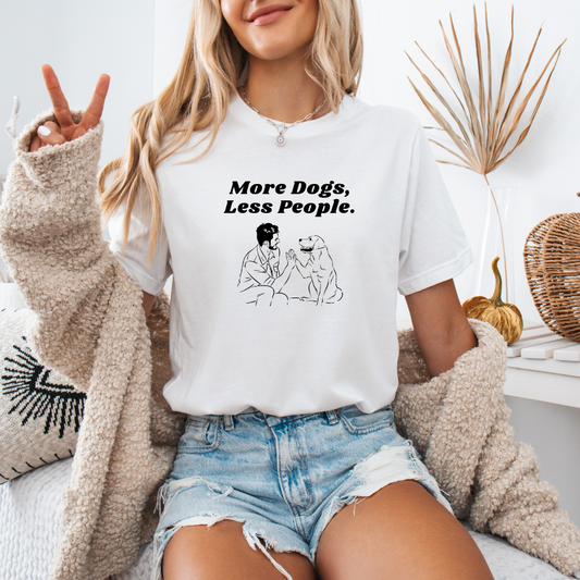 a woman sitting on a bed wearing a white shirt that says more dogs less people