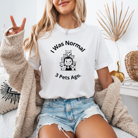 a woman sitting on a bed wearing a t - shirt that says i was normal